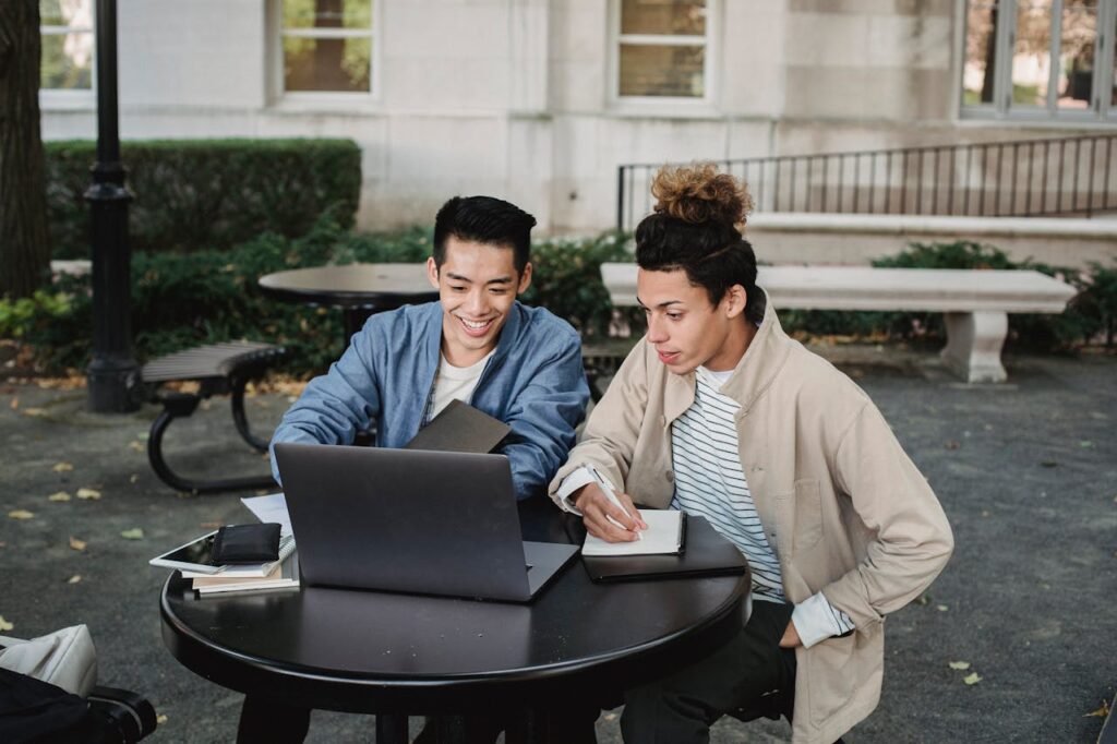 two person browsing on a laptop